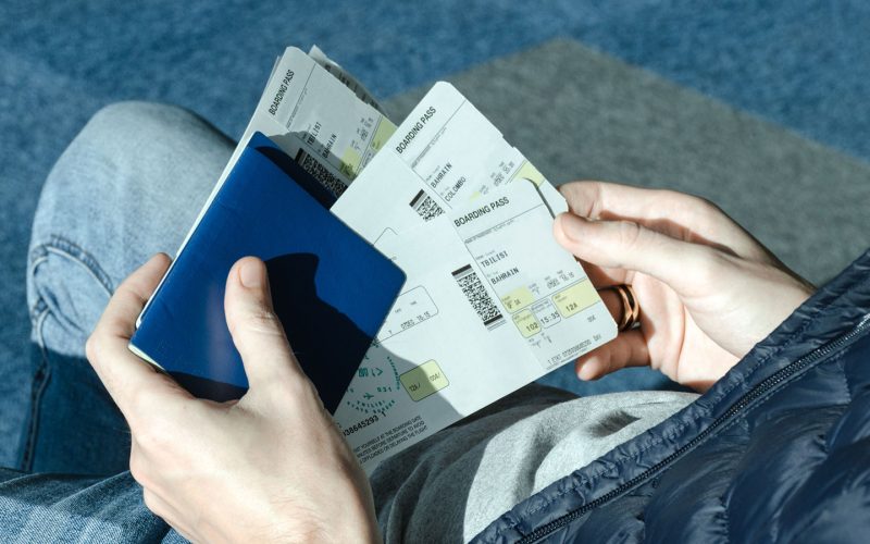 man-with-airplane-tickets-and-passport-4SYCE7N.jpg